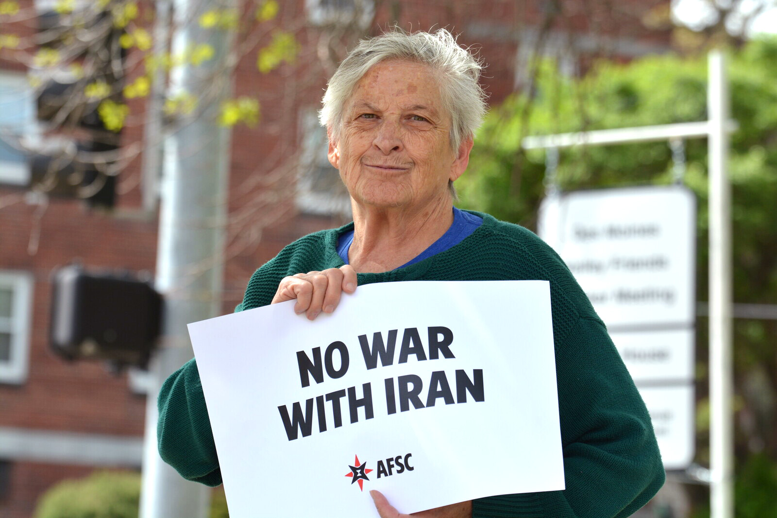 Woman holding a sign that reads 'No War With Iran'