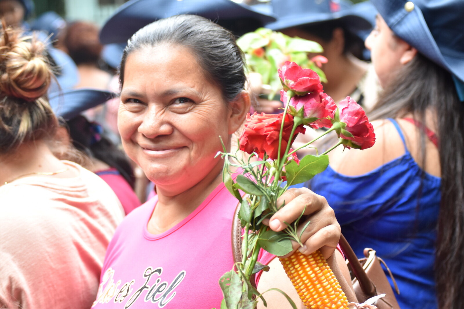 photo of woman smiling towards the camera and holding flowers
