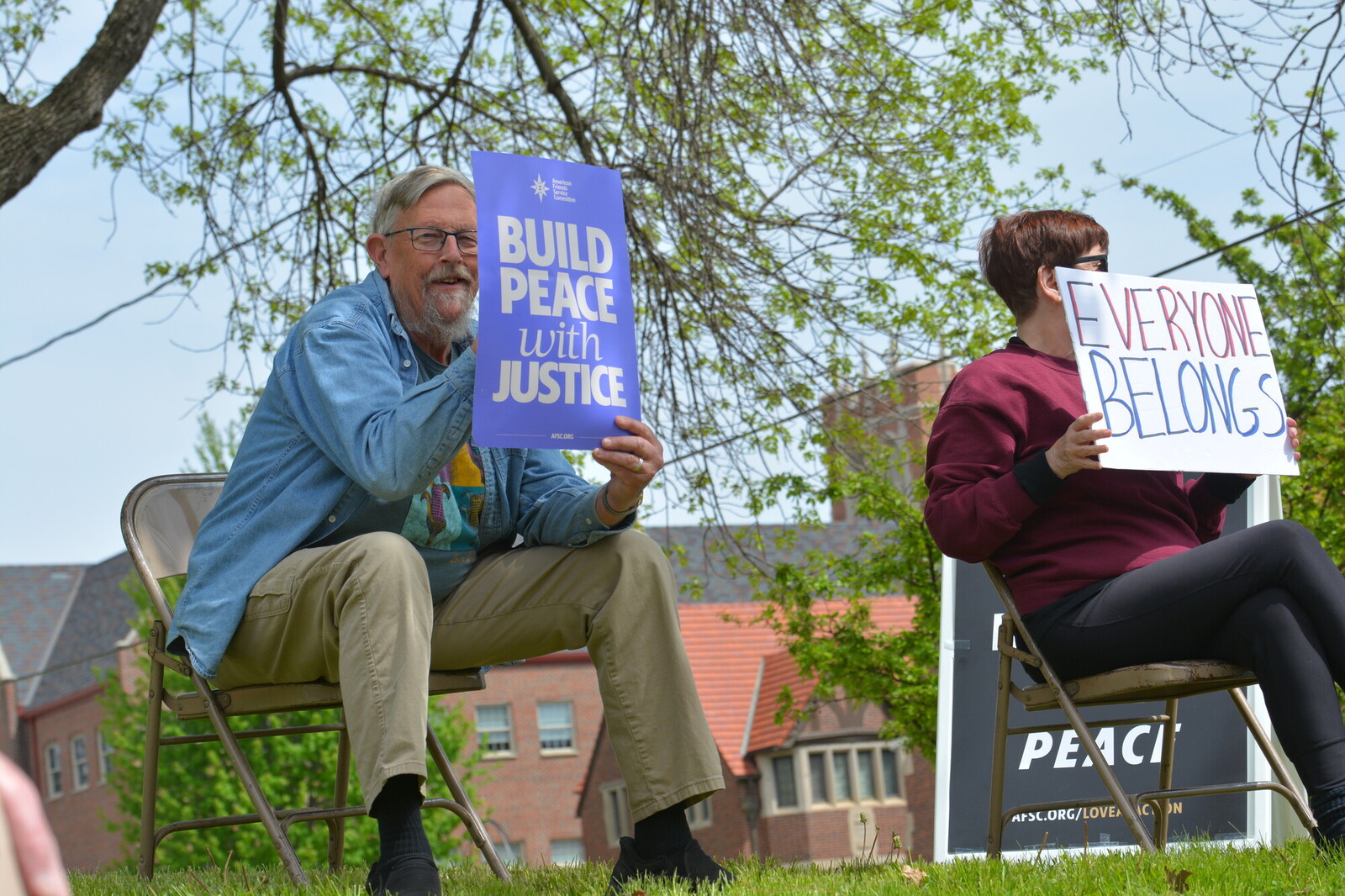 man sitting on chair sign says build peace with justice
