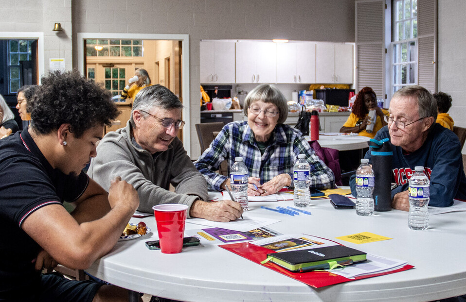 photo of people at a table talking to each other