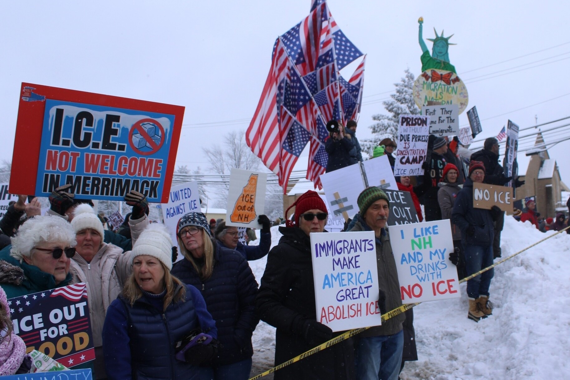 Picture of people protesting in cold weather with signs that read 
