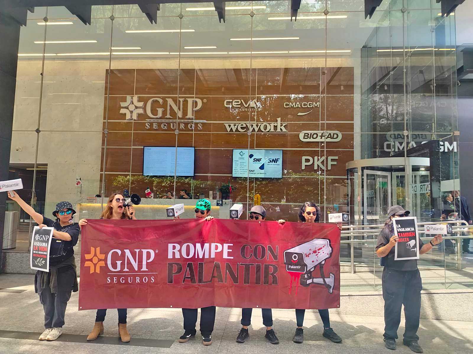 Protesters outside of GNP Seguros insurance company with a Spanish banner that translates to 