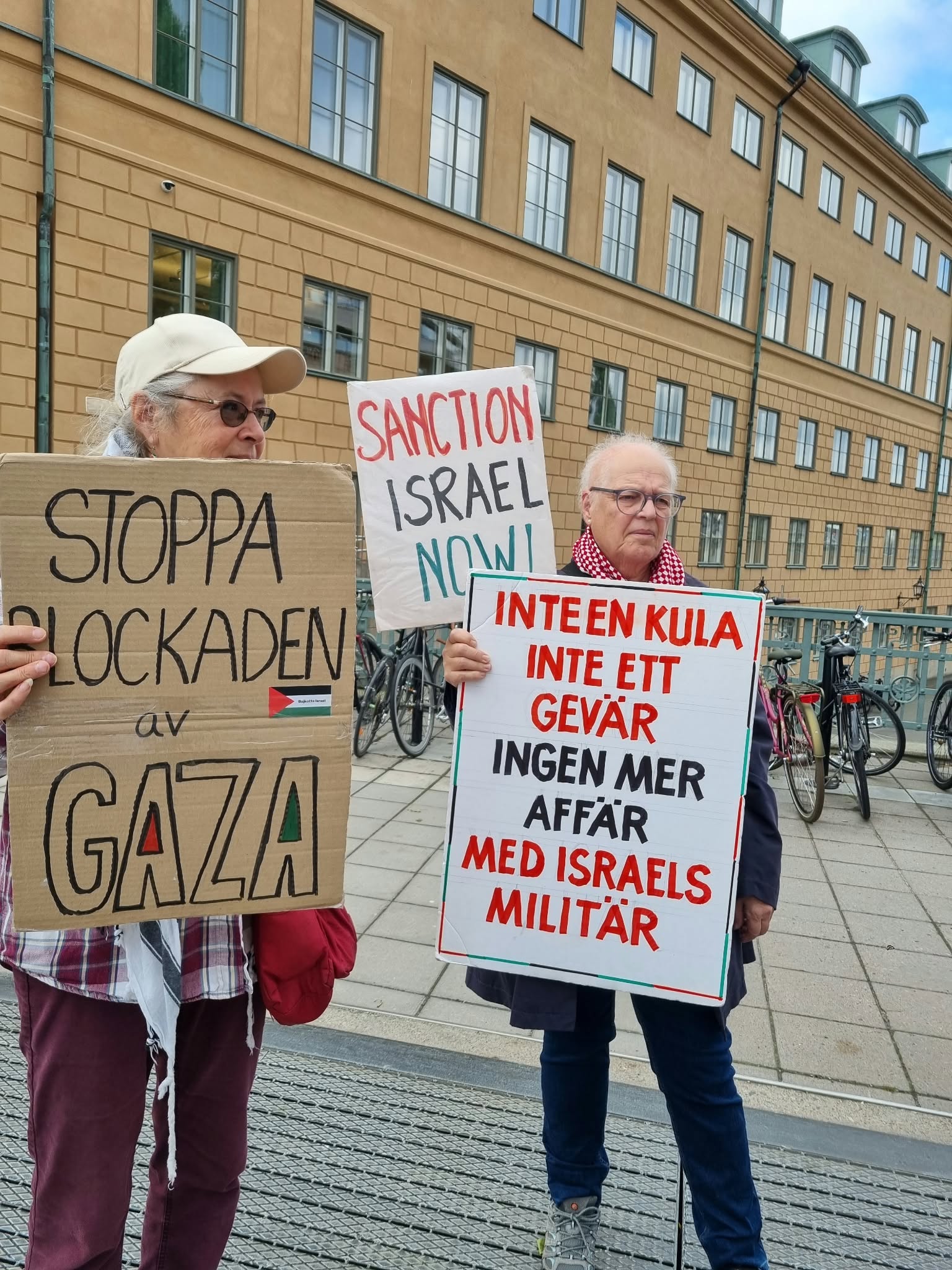 Palestine solidarity protestors holding signs calling for the Stockholm pension fund to divest from Palantir