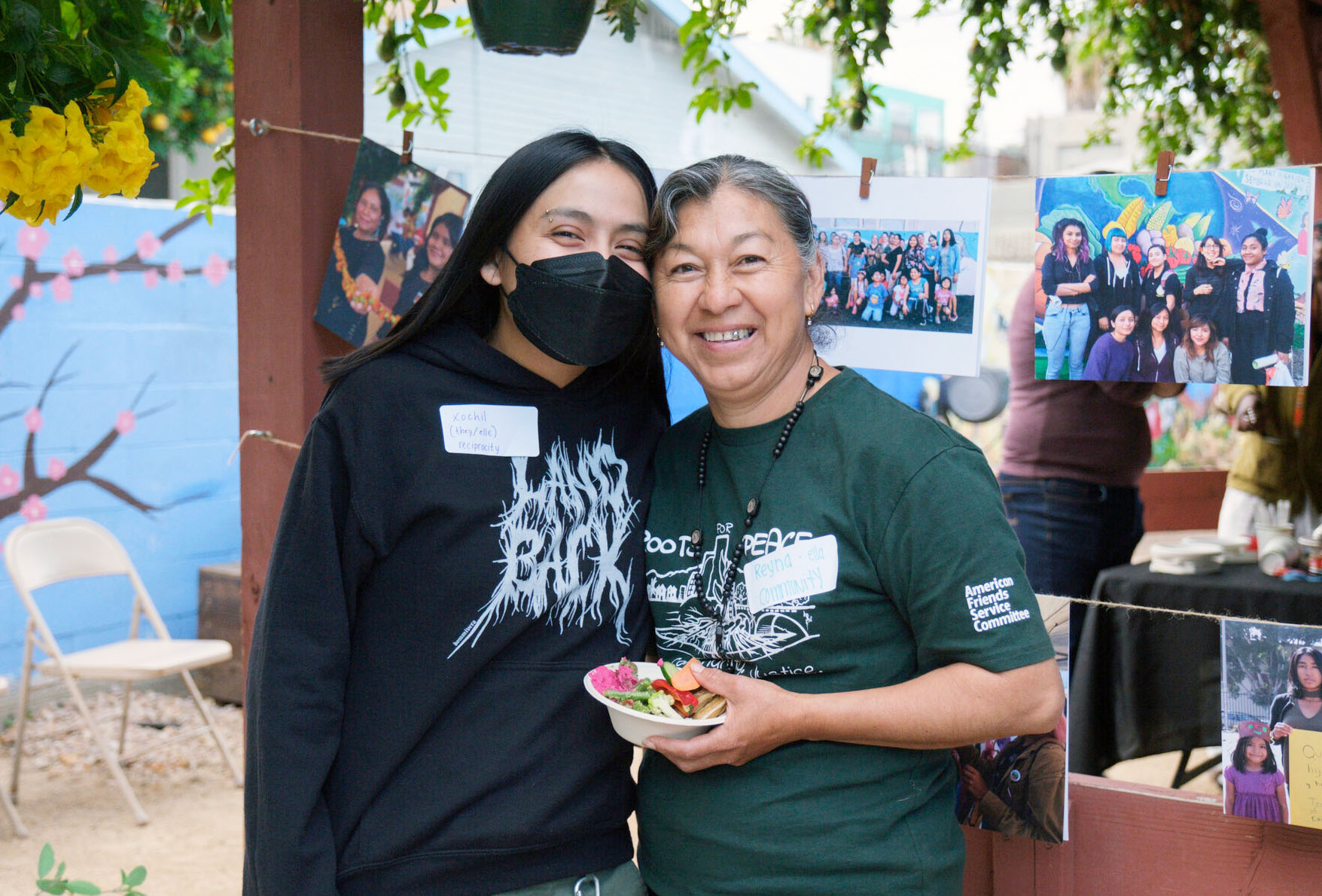 two people at a community garden smiling at the camera