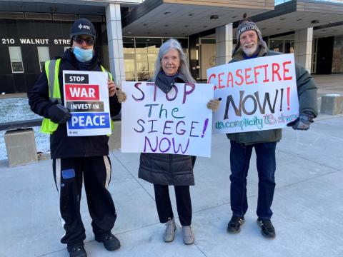 Quakers hold signs advocating for peace