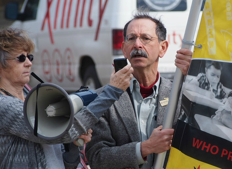 Arnie Alpert demonstrates against corporate influence on public policy in the lead-up to the 2016 presidential primary races. Photo: AFSC