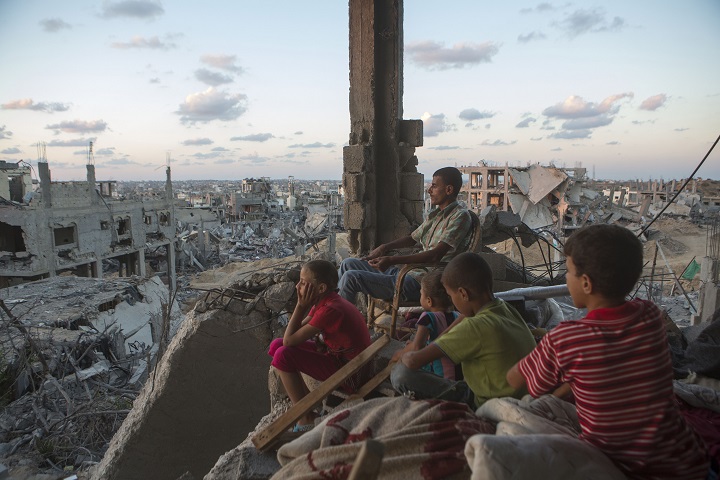 Family in a destroyed house in the At-Tuffah district in Gaza after the 2014 bombardment of Gaza, photo by Anne Paq of ActiveStills