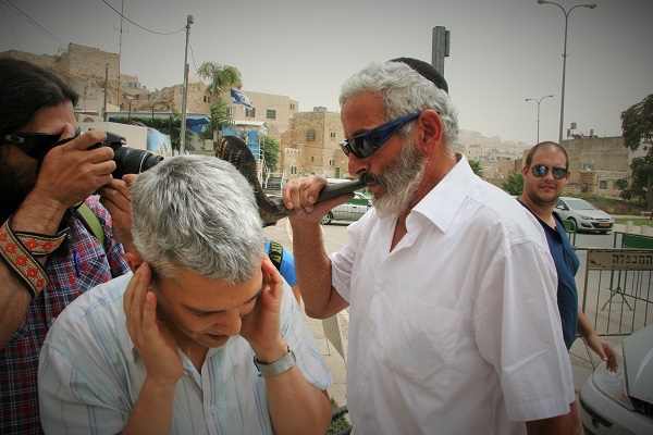 An Israeli settler blows his shofar after aggressively shoving my colleague Dalit.  According to Palestinian shopkeepers, he had been there all day disrupting the calls to prayer.